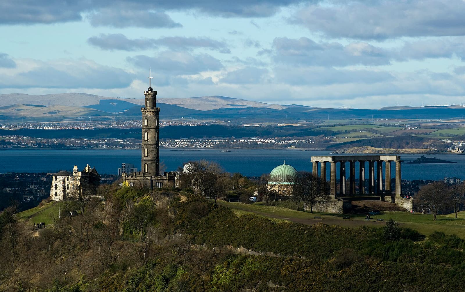 The Nelson Monument and the columns of the National Monument on Calton Hill, with the Firth of Forth behind