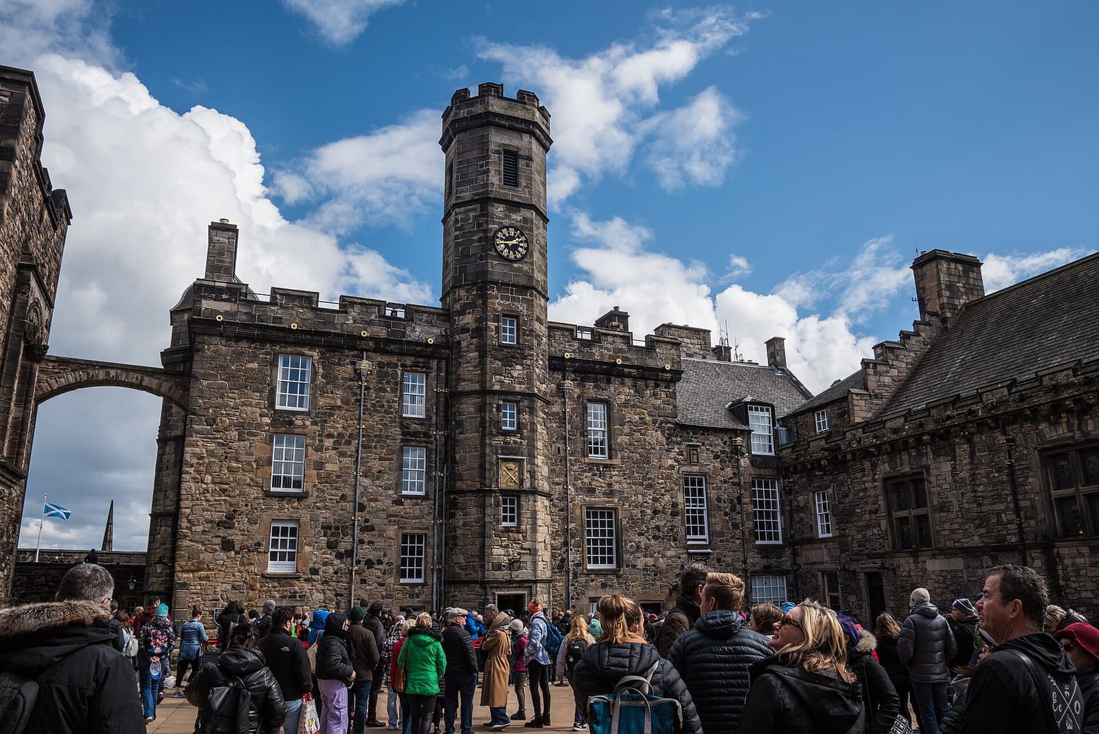 Visitors in Crown Square inside Edinburgh Castle, below the clock tower of the Royal Palace