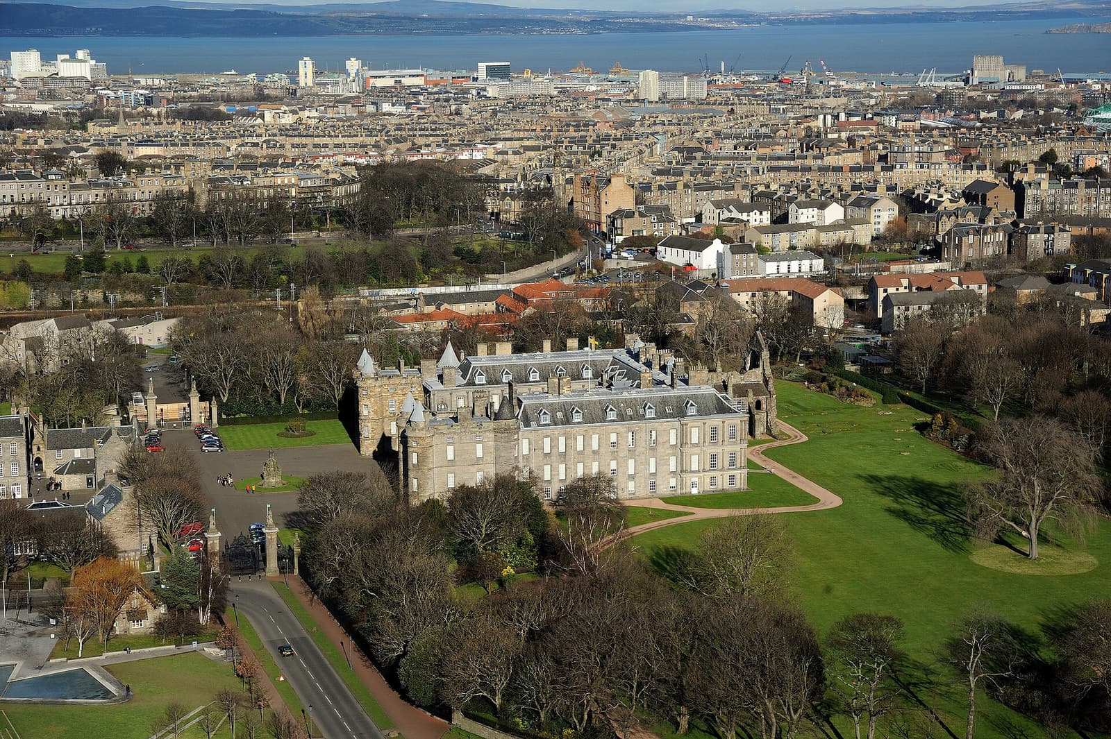 The Palace of Holyroodhouse and the ruined abbey beside it seen from above, with Edinburgh beyond