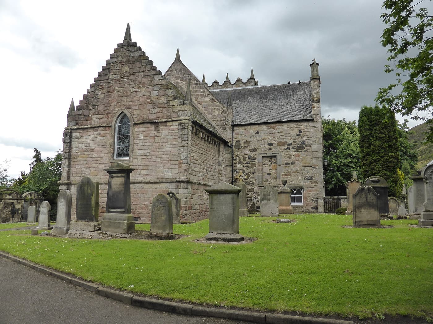 Duddingston Kirk, a small stone church, and gravestones in its churchyard