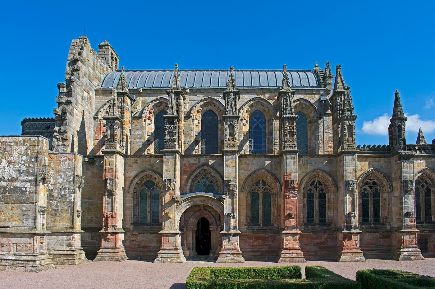 The ornate Gothic stonework of Rosslyn Chapel under a clear blue sky