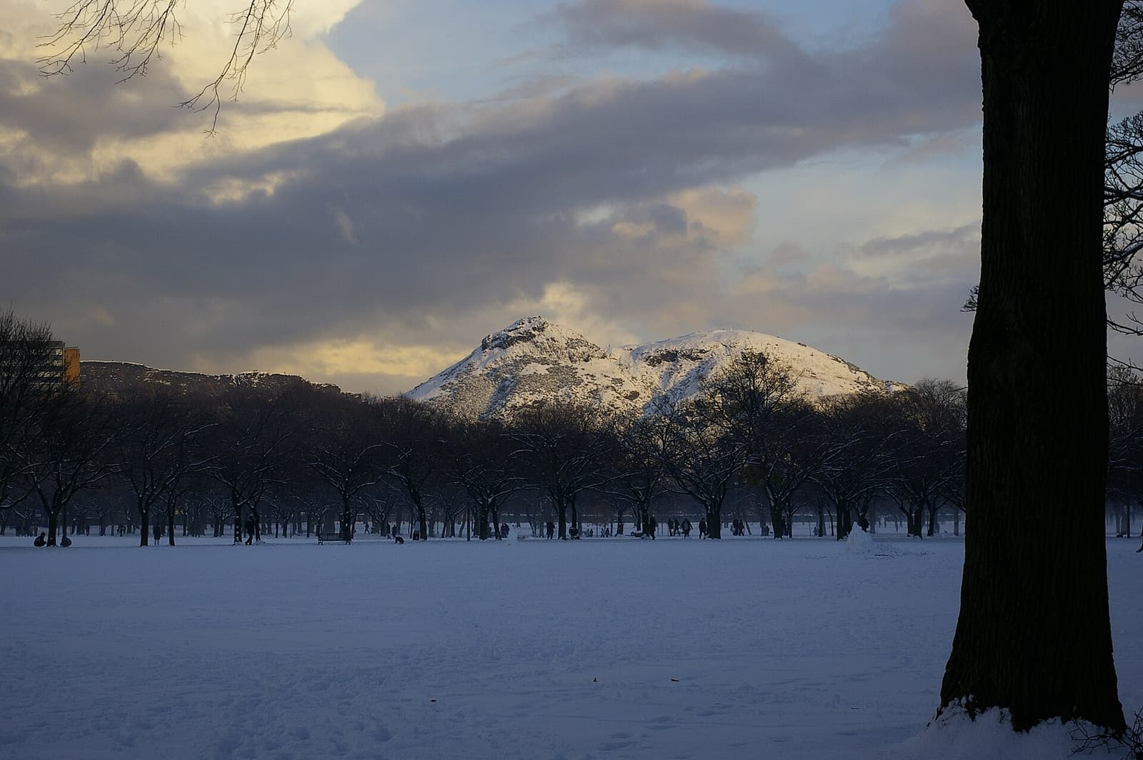 Arthur’s Seat dusted with snow, seen across a snow-covered park in winter